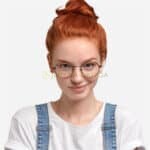 Mujer joven pelirroja con gafas, sonriendo