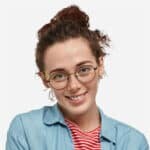 Mujer joven sonriendo con gafas y camisa azul
