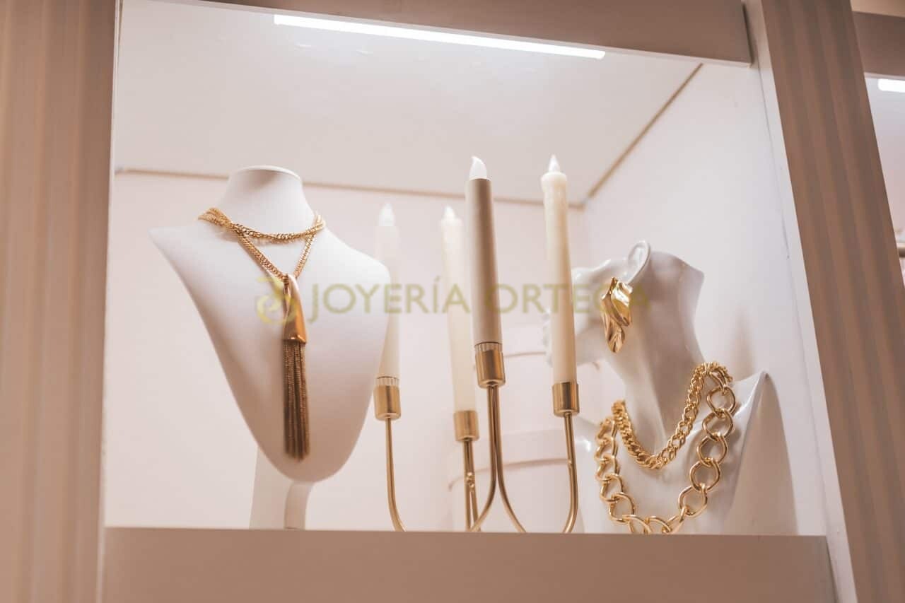 Maniquíes exhibiendo joyas doradas en escaparate