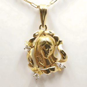 Medalla dorada con figura religiosa y diamantes.