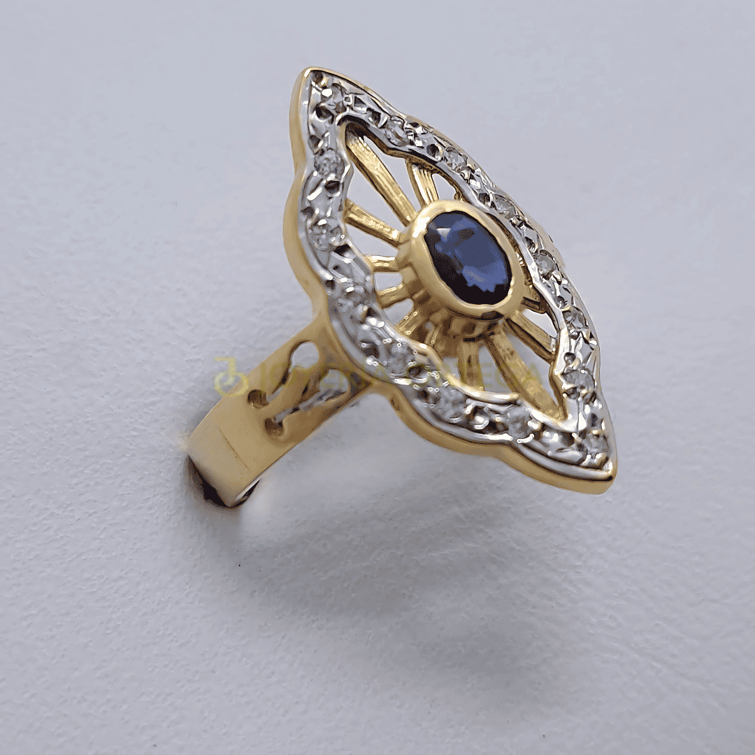 Anillo dorado con zafiro azul y detalles brillantes