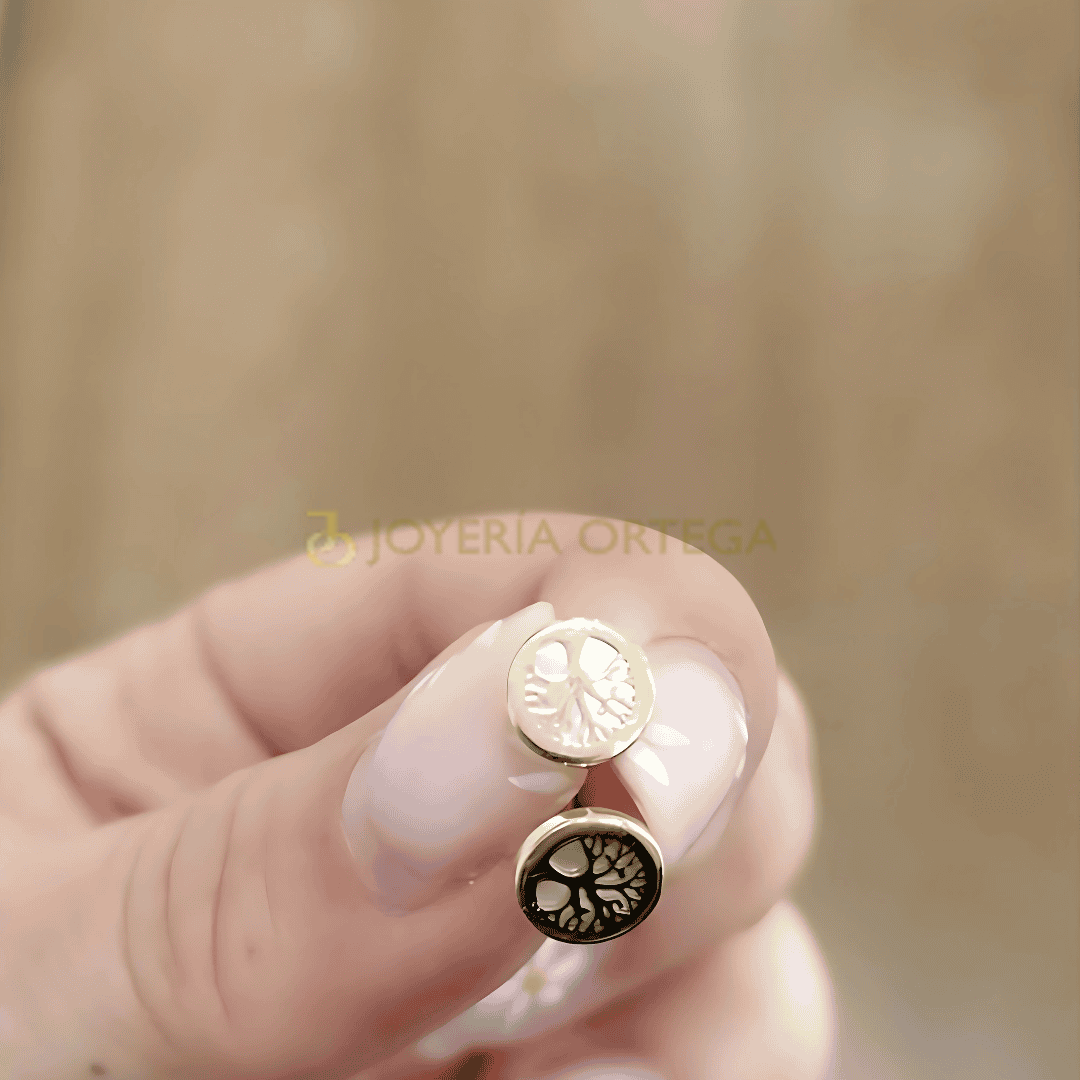 Pendientes árbol dorado y oscuro en mano